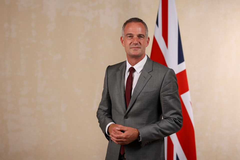 Peter Kyle stands in front of Union Jack flag